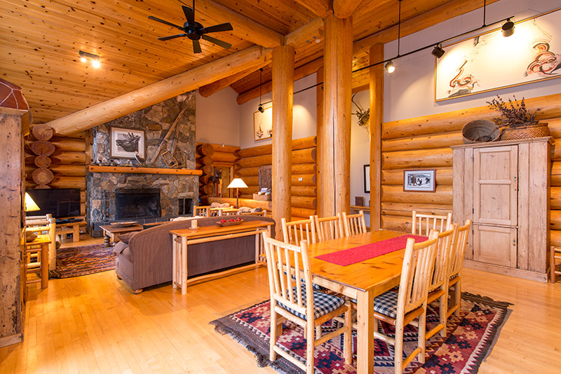 Vaulted ceilings in log home living room with massive slate rock fireplace and 18' cedar logs